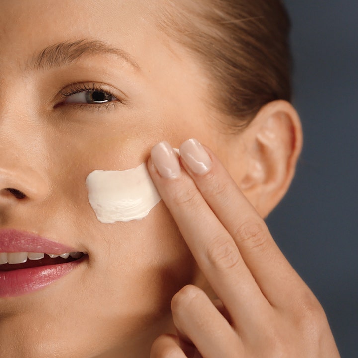 Estée Lauder Revitalizing Supreme + Night Cream 50 ml opstrammende natcreme påføres med fingrene på kinden.