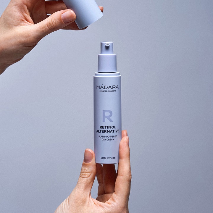 MÁDARA Retinol Alternative Plant-Powered Day Cream 50 ml dagcreme i lilla pumpeflaske der holdes i hænderne