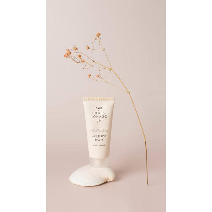 Care by Therese Johaug Multi Use Balm 30 ml med Vitamin E beskytter tør hud i hvid tube stående på en muslingeskal.