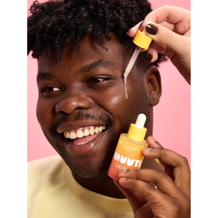 Smuuti Skin Peach Barrier Serum 30 ml styrkende serum påføres med pipette på en smilende mand med glød
