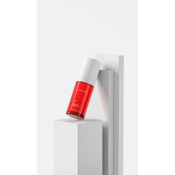 Niche Beauty Lab Theramid Azid 30 ml serum mod rødme i rød gennemsigtig flaske på hvide geometriske podier.