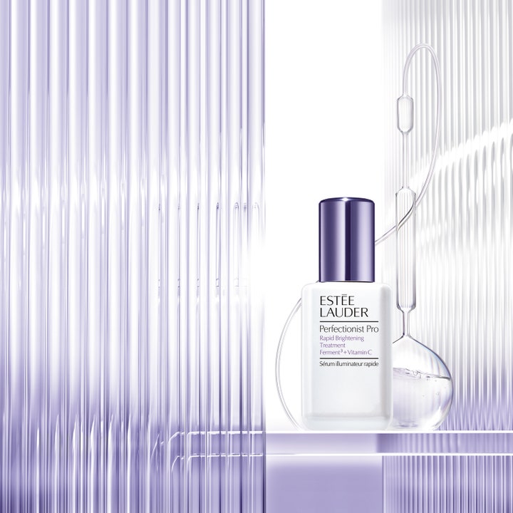 Estée Lauder Perfectionist Pro 30 ml serum med C-vitamin i hvid flakon med lilla låg ved laboratorieglas