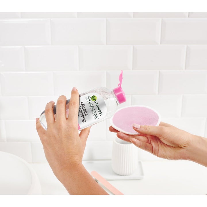Garnier Reusable Eco Pads Duo 6 stk. fjerner makeup effektivt mens micellar water hældes på en lyserød rondel