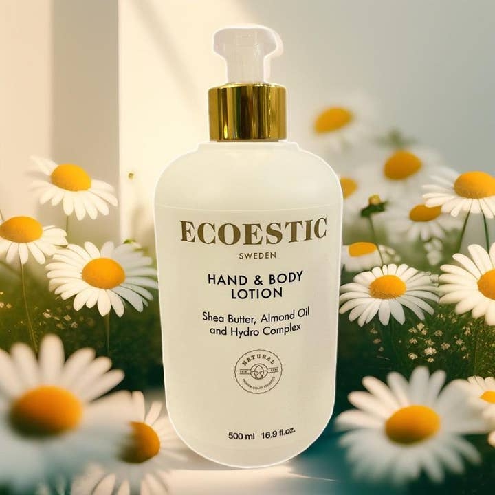 ECOESTIC Hand & Body lotion 500 ml giver fugt i hvid pumpeflaske omgivet af hvide margueritter