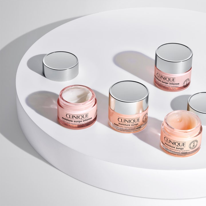 Clinique Moisture Surge 100H 75 ml fugtgivende ansigtscreme i lyserøde krukker med sølvlåg på hvid platform.