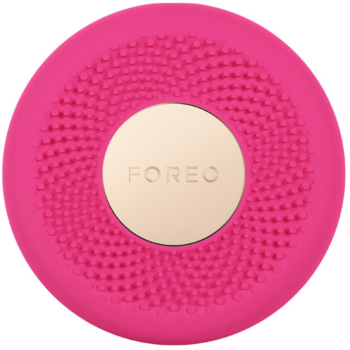 Foreo UFO 1 stk ansigtsbehandling til hjemmebrug som en rund fuchsia silikoneenhed med præget mønster og guldlogo.