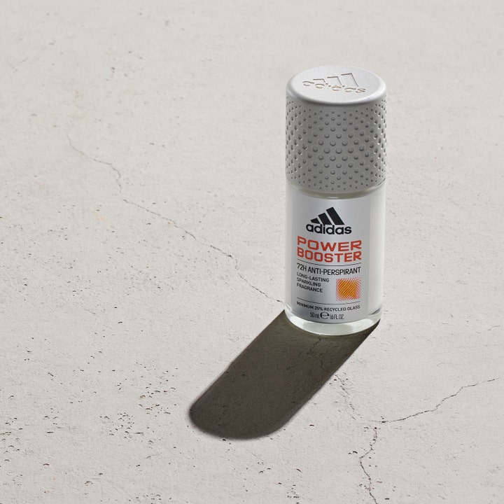 Adidas Power Booster 50 ml roll-on deodorant mod sved i klar glasflaske med gråt mønstret låg på rå beton.