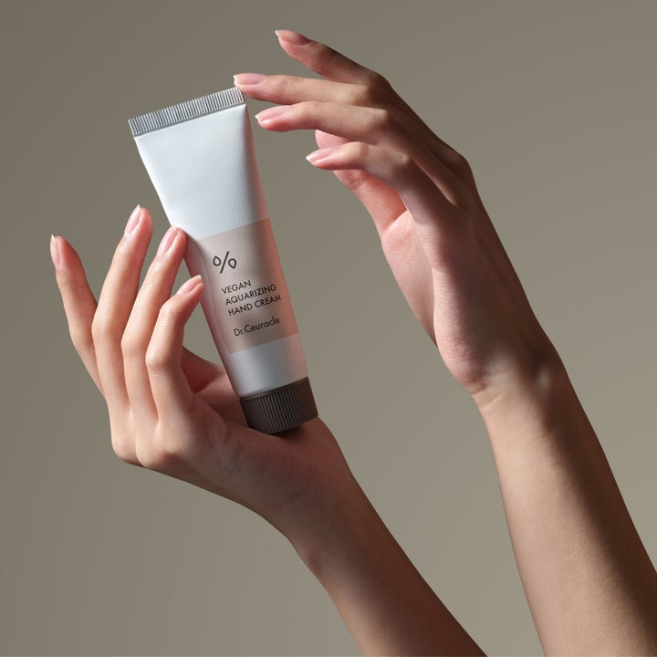 Dr. Ceuracle Vegan Aquarizing Hand Cream 50 ml fugtgivende håndcreme i hvid tube holdt af to hænder