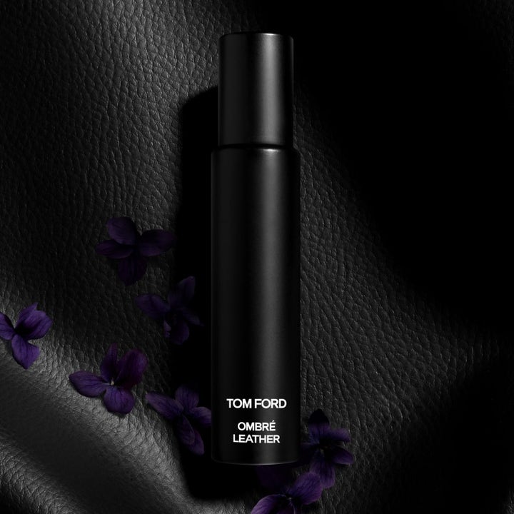 Tom Ford Ombré Leather EdP parfume i mat sort flaske på sort læderbaggrund med lilla blomster