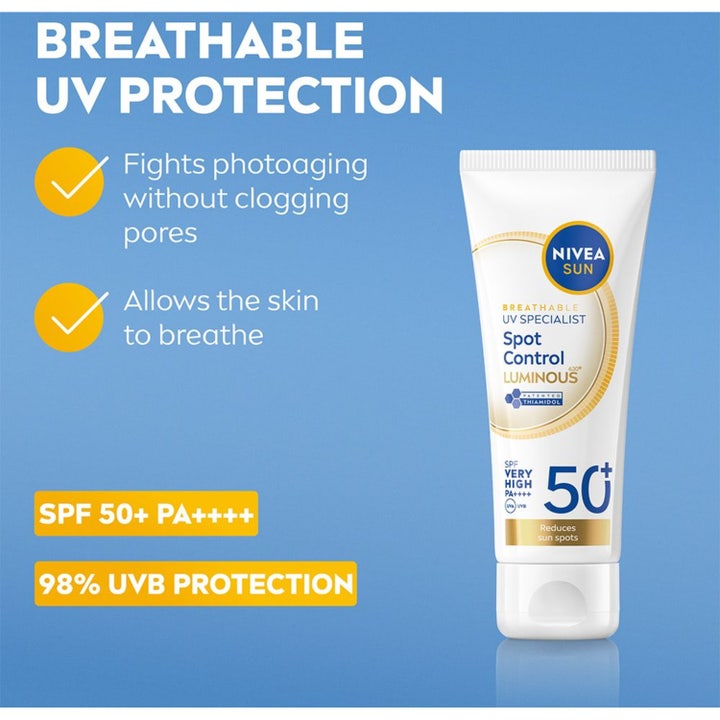 NIVEA UV Face Luminous630 40 ml solcreme mod mørke pletter viser en smilende kvinde med creme på kinden mod blå himmel
