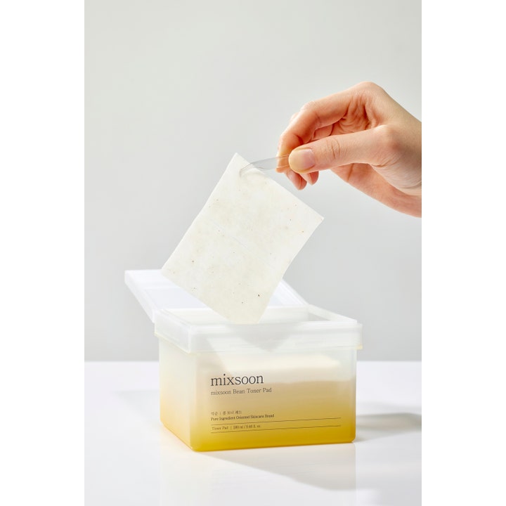 Mixsoon Bean Toner Pad 70 stk fugtgivende toner pads i frostet beholder med pincet der løfter en firkantet pad.