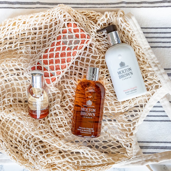 Molton Brown Heavenly Gingerlily Bath & Shower Gel 300 ml velduftende badegel vist i en flettet beige nettaske