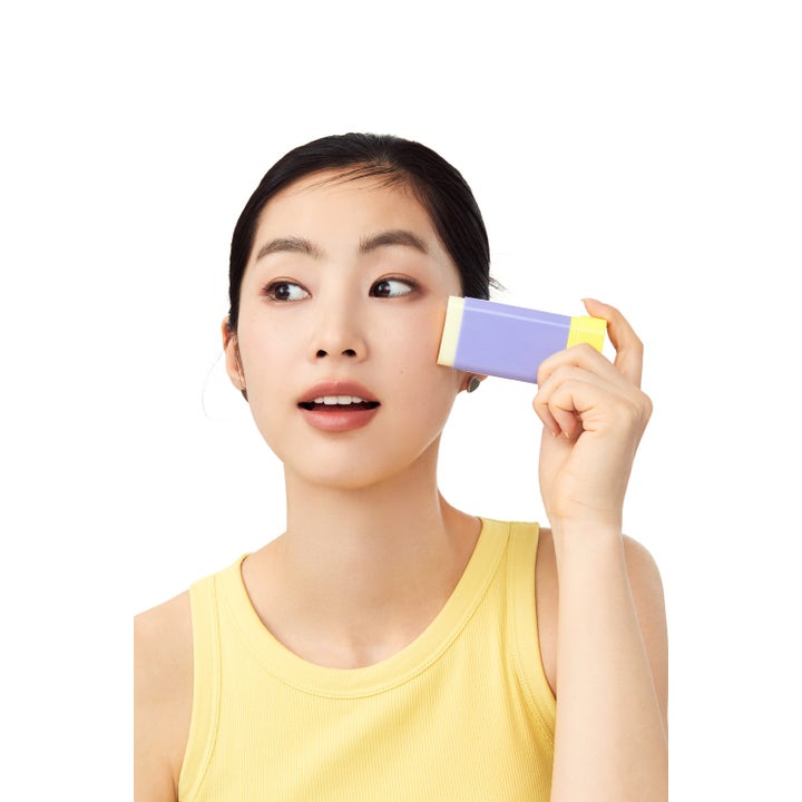 By Wishtrend Pore Smoothing Bakuchiol Sun Stick 18 g udglattende solcremestift som en kvinde påfører på sin kind