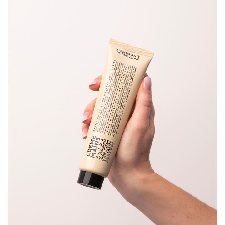 Compagnie de Provence Hand Cream Shea Butter 100 ml ultra-nærende håndcreme i beige tube som holdes i en hånd