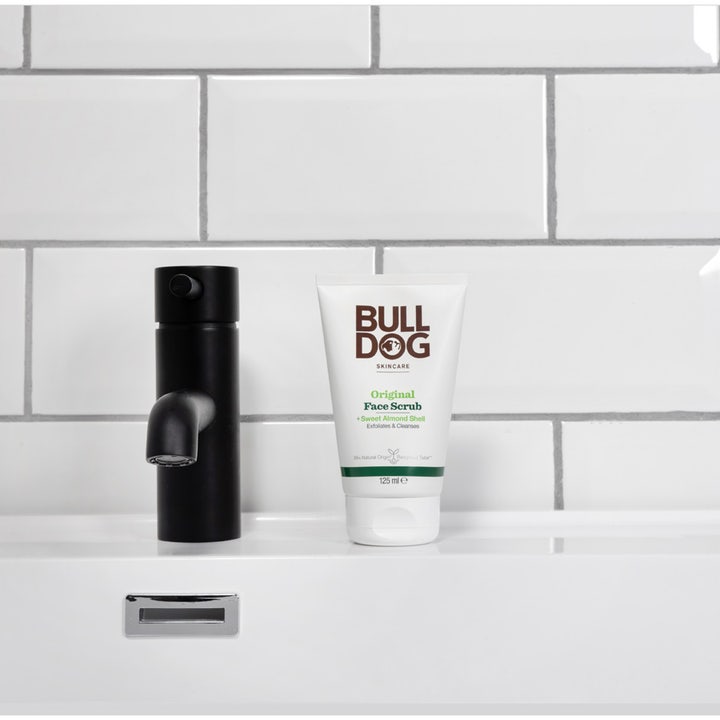 Bulldog Original Face Scrub 125 ml eksfolierende peeling i hvid tube ved en sort vandhane og hvide fliser