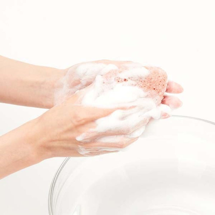 Purito Bamboo Charcoal Konjac Sponge 7 g eksfolierende rensesvamp der danner hvidt skum mellem hænderne