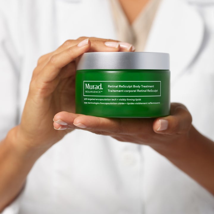 Murad Retinal ReSculpt Body Treatment 148 ml opstrammende bodylotion i grøn krukke med sølvlåg holdt af hænder