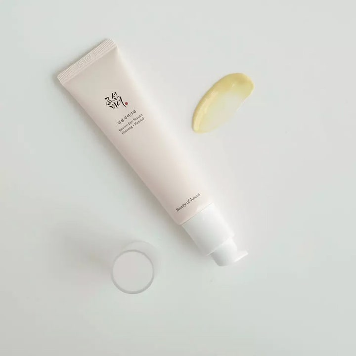 Beauty of Joseon Revive Eye Serum mod rynker i beige tube med pumpe og en klat cremet gul serum ved siden af.