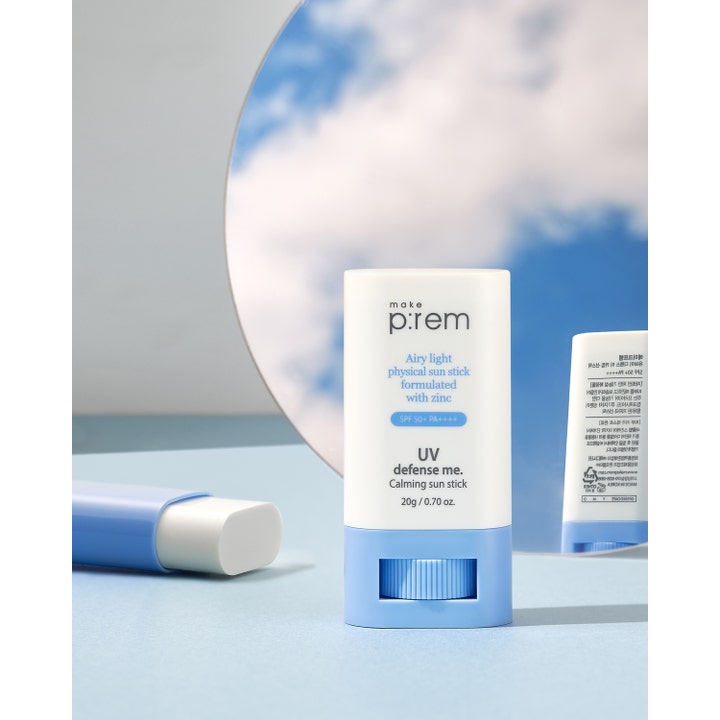 Make Prem UV Defense Me Calming Sun Stick 20 g beroligende solstift med SPF 50+ og zink foran spejl med skyer.