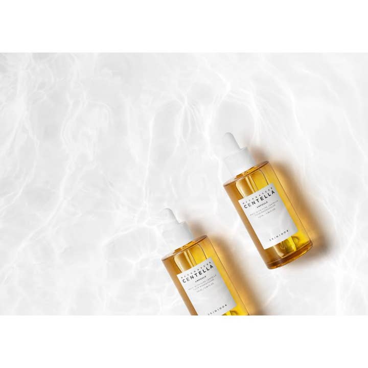 SKIN1004 Madagascar Centella Ampoule 100 ml beroligende serum i glasflasker placeret i klart, kruset vand