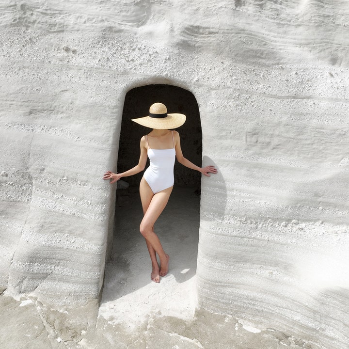KORRES Yoghurt Tinted Sunscreen Face Cream SPF30 50 ml solbeskyttelse vist med kvinde i hvid badedragt ved hvide klipper