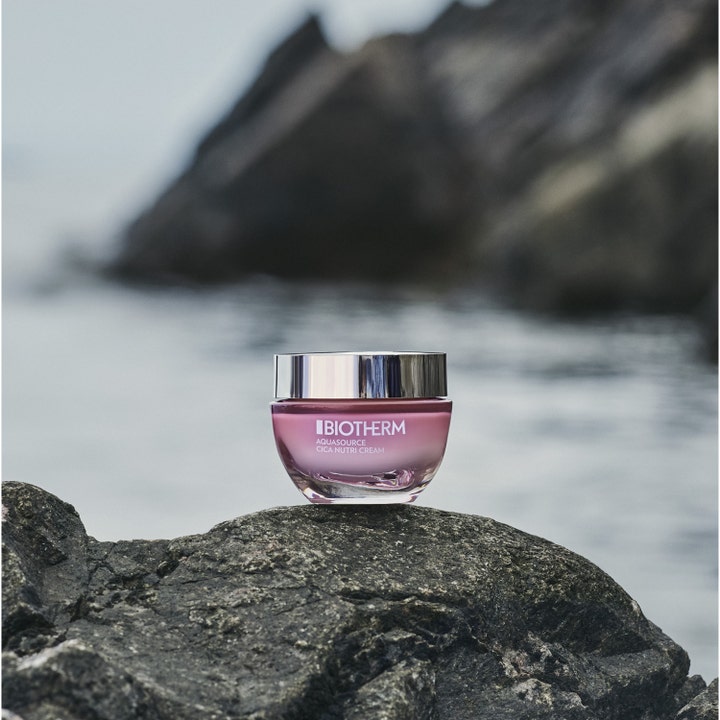Biotherm Aquasource Cica Nutri 30 ml fugtgivende dagcreme i lyserød krukke med sølvlåg på en klippe ved vandet