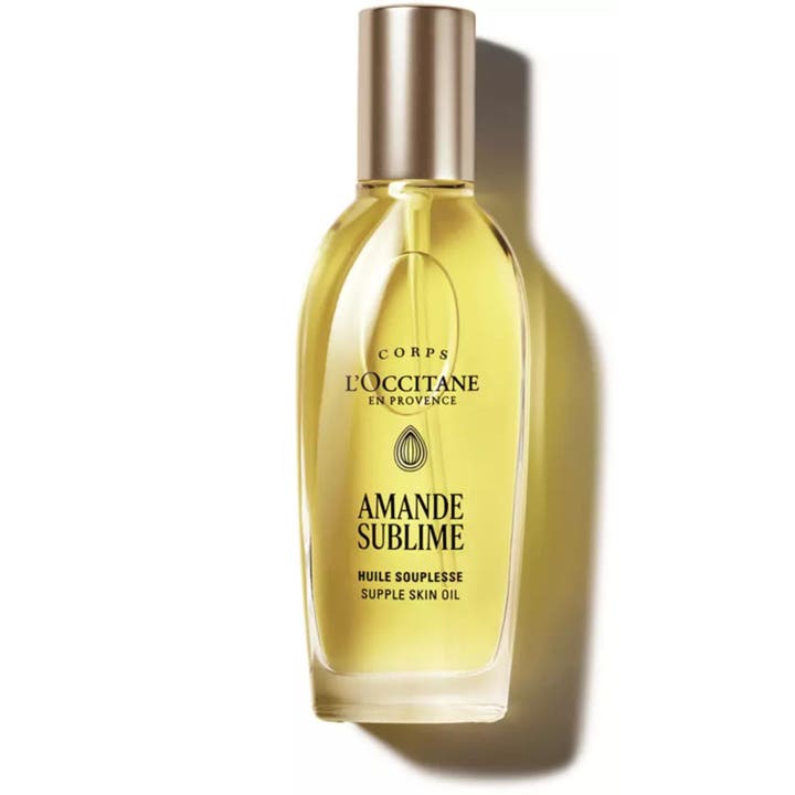 L'Occitane Amande Supple Skin Oil 100 ml kropsolie med mandelolie i klar glasflaske med sølvpumpe og gylden olie