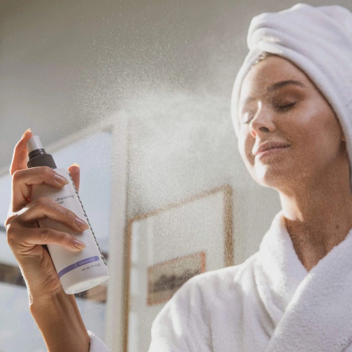 Dermalogica UltraCalming Mist Duo 177 ml beroligende toner sprayes over ansigtet af kvinde i hvid badekåbe