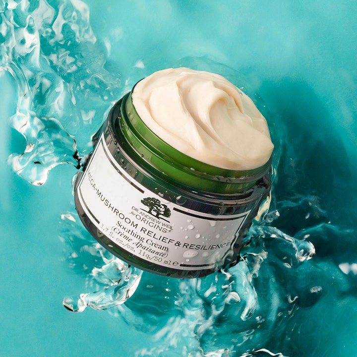 Origins Dr. Weil Mega-Mushroom Relief & Resilience 50 ml beroligende ansigtscreme i åben grøn krukke i vandstænk