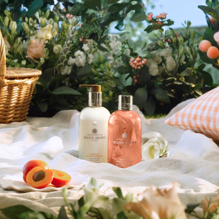 Molton Brown Graceful Apricot & Freesia Body Lotion 300 ml i et sommerligt picnicmiljø med friske abrikoser