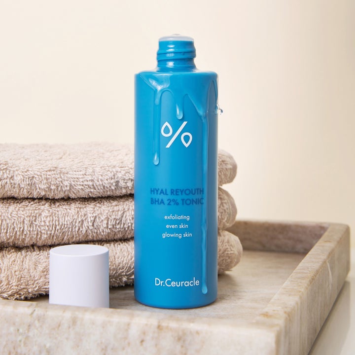 Dr. Ceuracle Hyal Reyouth BHA 2% Tonic 100 ml eksfolierende toner i blå flaske med flydende gel på en stentray