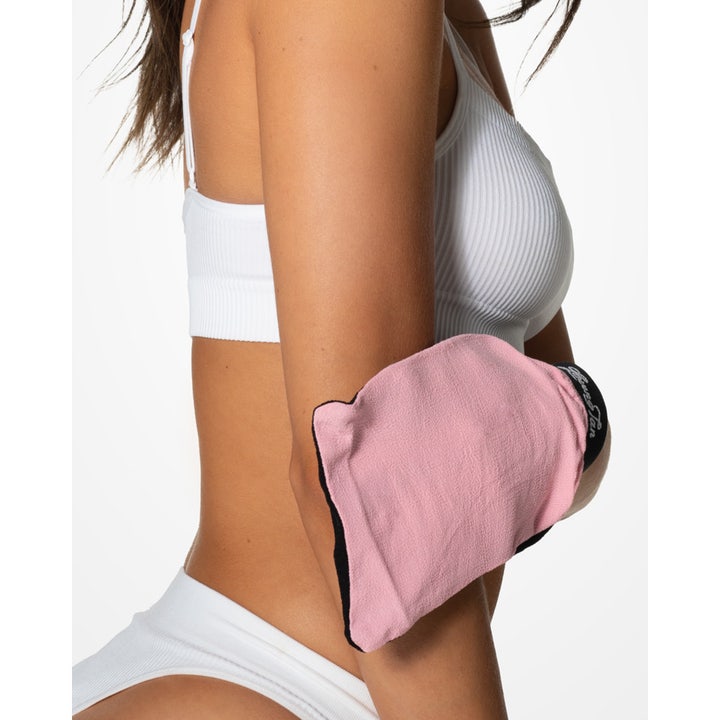 Loving Tan Tan Removing & Skin Polishing Glove 1 stk eksfolieringshandske i pink og sort der fjerner selvbruner på albuen
