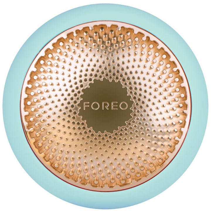 Foreo UFO Mint ansigtsmaske enhed til hudpleje med rund lyseblå form og guldstruktureret behandlingsflade