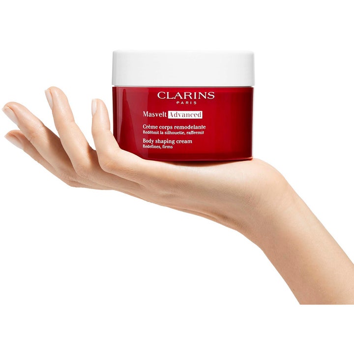 Clarins Masvelt Advanced Body Shaping Cream 200 ml opstrammende bodylotion i rød krukke holdt i en hånd