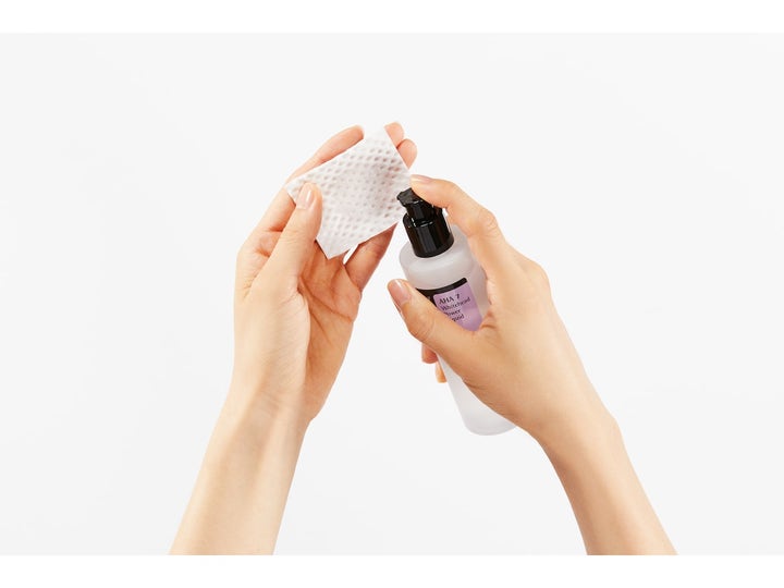 COSRX AHA 7 Whitehead Power Liquid 100 ml eksfolierende toner der pumpes ud på en vatrondel