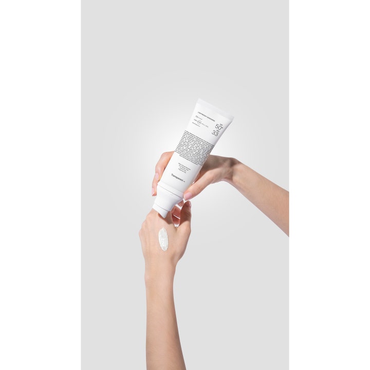 Niche Beauty Lab Transparent Lab Lightweight Sunscreen 100 ml solcreme påføres som hvid creme på en hånd