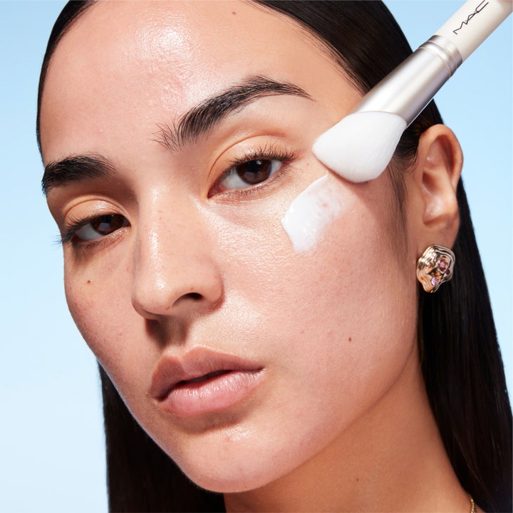 MAC Cosmetics Serum + Moisturizer Brush 1 stk. påfører hvid fugtgivende creme på huden for en jævn finish.