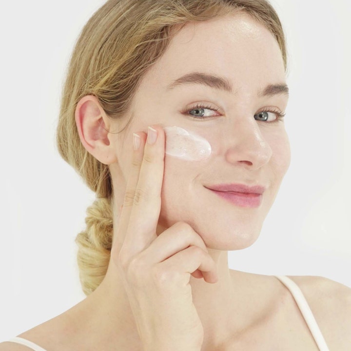 Purito Dermide Relief Barrier Moisturizer 100 ml beroligende ansigtscreme påføres på huden af en smilende kvinde