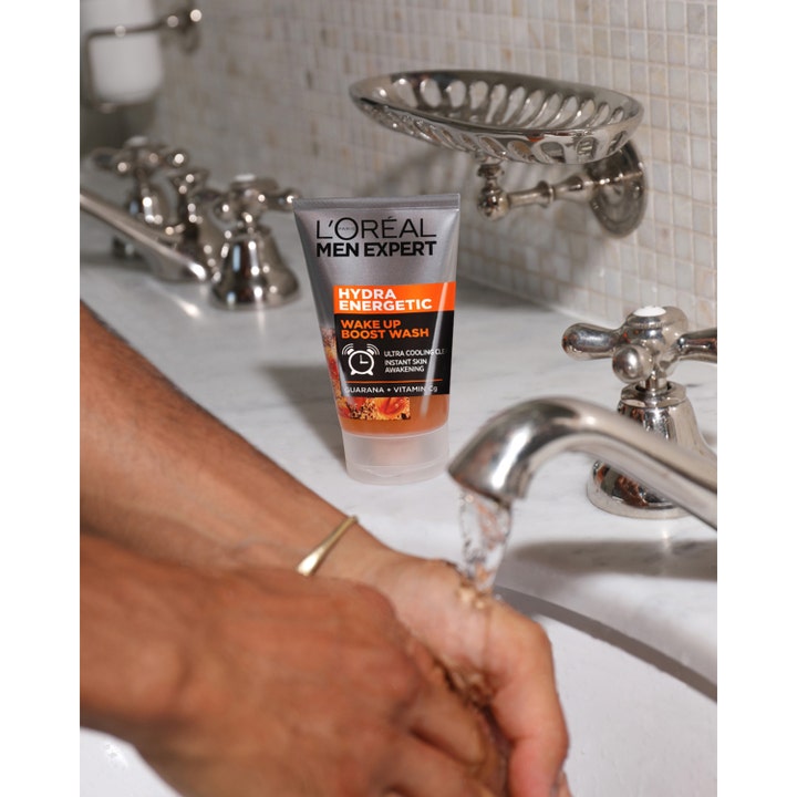 L'Oréal Paris Men Expert Hydra Energetic Wash 100 ml ansigtsrens med vitamin C på marmorhåndvask ved rindende vand.