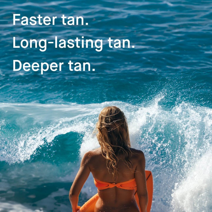 EVY Technology Daily Tan Activator & After Sun giver en faster og deeper tan. Kvinde med surfboard i blåt hav.