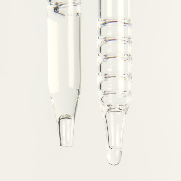 Bronza Glow Drops 30 ml tanning drops giver glød vist som klar væske i to tynde glaspipetter