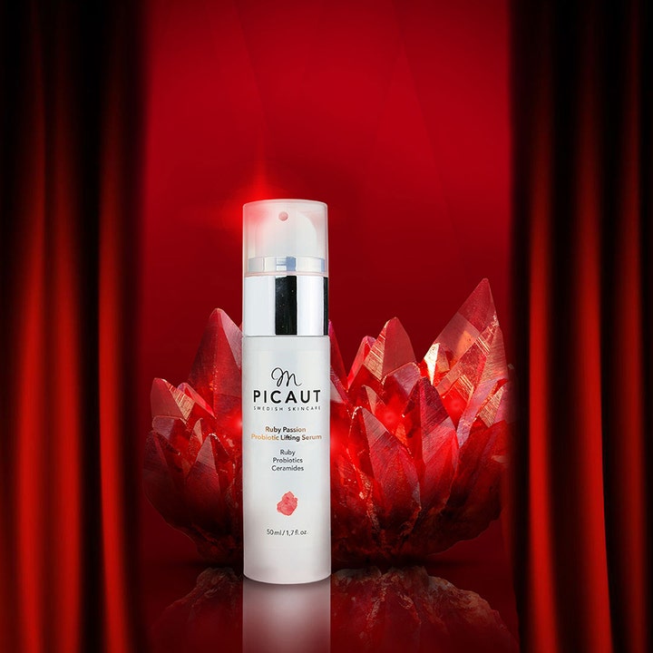 M Picaut Ruby Passion Probiotic Lifting Serum 30 ml opstrammende ansigtsserum foran røde krystaller og gardiner.