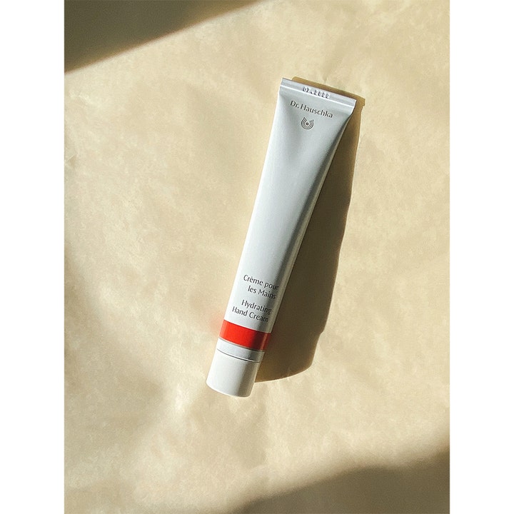 Dr. Hauschka Hand Cream 50 ml plejende håndcreme i hvid tube med rød detalje på beige baggrund