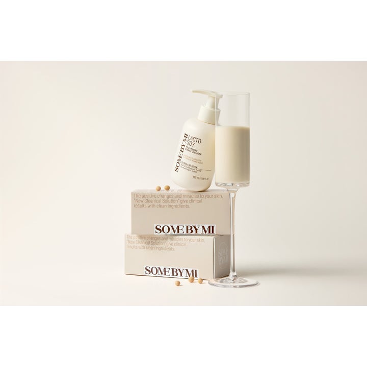 Some By Mi Lactosoy Mild Bubble Peeling Cleanser 180 ml mild renseskum i hvid pumpeflaske ved et glas mælk