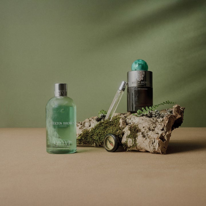 Molton Brown Wild Mint & Lavandin 300 ml forfriskende showergel i grøn flaske ved bark, mos og et lille kompas