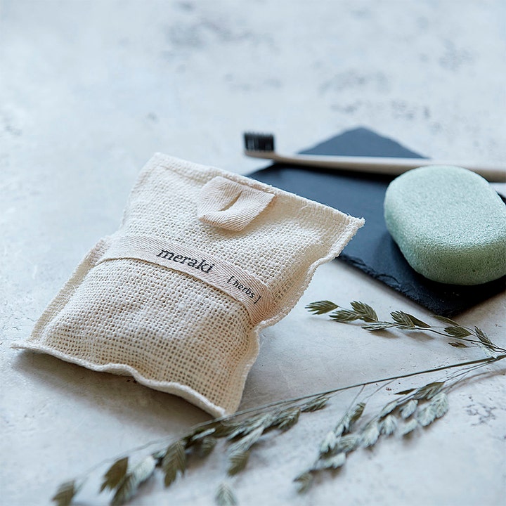 Meraki Bath Mitt Herbs 140 g eksfolierende badepose i beige vævet stof med meraki label og grøn badesæbe
