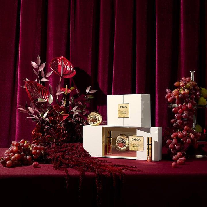 Babor HSR Gift Set 60 ml anti-age hudplejesæt mod rynker i hvide æsker med guld ved rødt fløjlsgardin og vindruer.