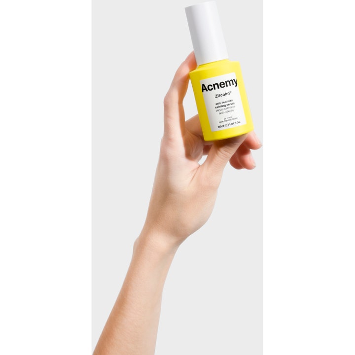 Niche Beauty Lab Acnemy Zitcalm Serum 30 ml beroligende ansigtsserum i gul flaske holdt af en hånd