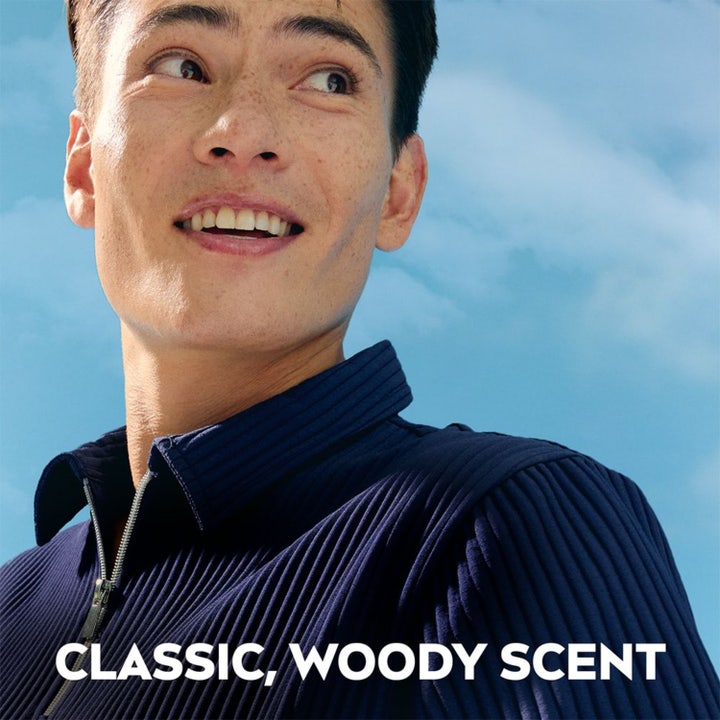 NIVEA Dry Impact Stick 50 ml deodorant til mænd med Classic Woody Scent vist med smilende mand mod blå himmel.