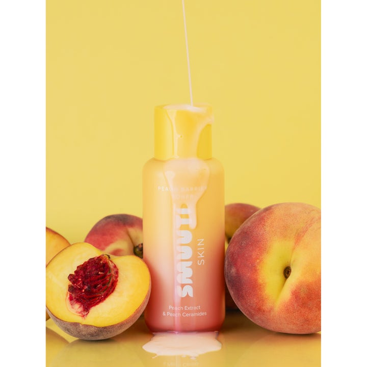 Smuuti Skin Peach Barrier Toner 130 ml fugtgivende toner med mælkehvid konsistens omgivet af friske ferskner.